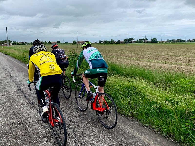 Die Gruppe mit Regenschutz auf dem Rennrad entflieht dem Regen