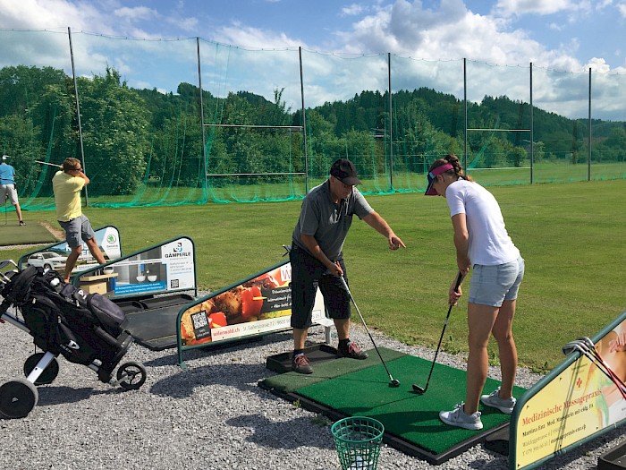 Walti erklärt Denise genau, wie man beim Golf abschlägt