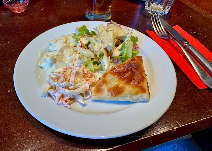 Ein Teller mit herzaften Sachen wie Hackfleischtaschen und Salat