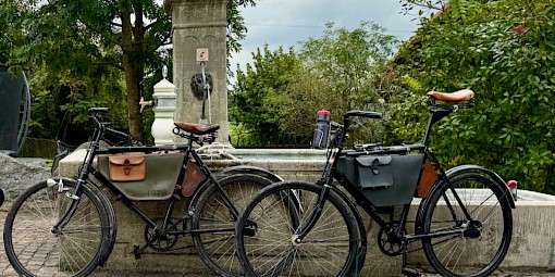 Zwei Militärräder stehen beim Brunnen in Langenmoos